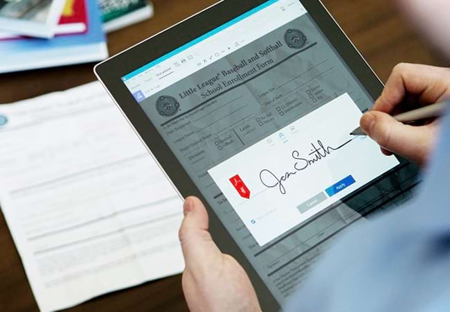 Hình ảnh người đàn ông đang dùng bút điện tử để ký chữ ký trên chiếc máy tính bảng