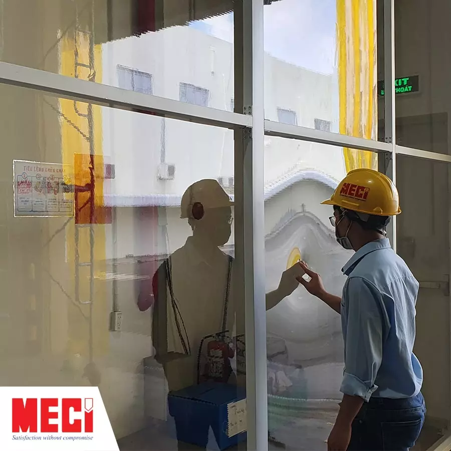 Một người đứng cạnh vách ngăn pvc