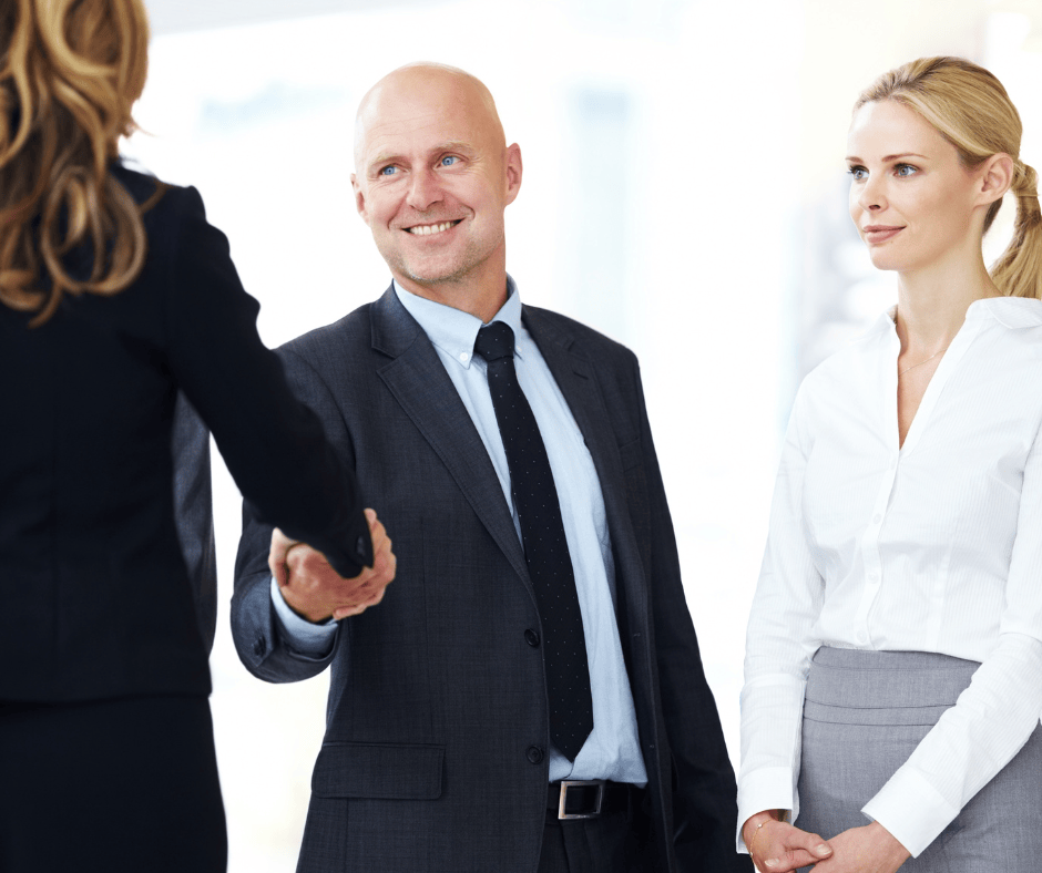 Người đàn ông cùng cộng sự của mình đang bắt tay chào hỏi đối tác. 