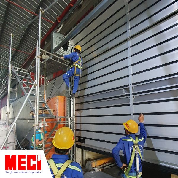 1 kỹ thuật đang thi công hộp cuốn cửa cuốn nhanh nan nhôm, 2 kỹ thuật quan sát từ bên dưới