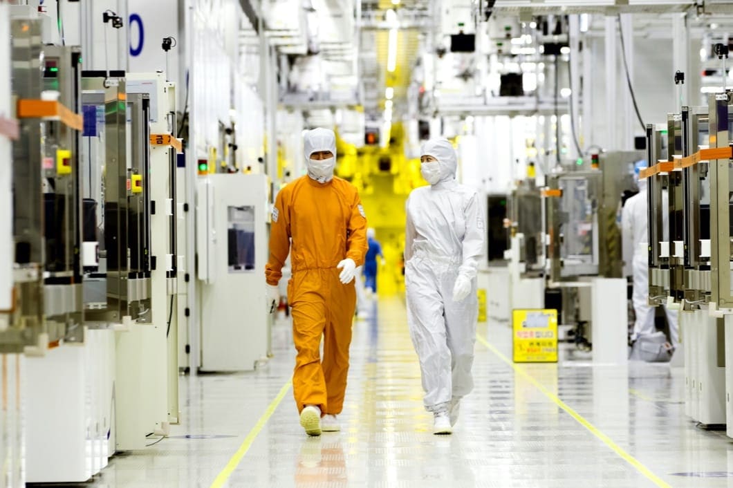 Hai kỹ thuật viên tại phòng sạch mặc đồ bảo hộ áo liền quần kèm mũ