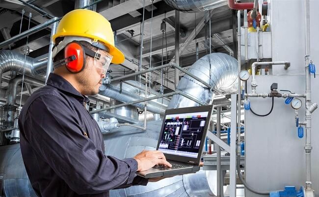 Kỹ sư đang đánh giá hệ thống điện tại nhà xưởng qua bản vẽ và thực tế