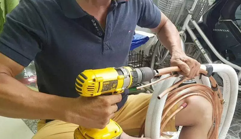 Người thợ đang dùng máy chỉnh sửa cho ống đồng điều hòa