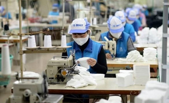 Công nhân mặc áo xanh dương đang làm việc tại xưởng may