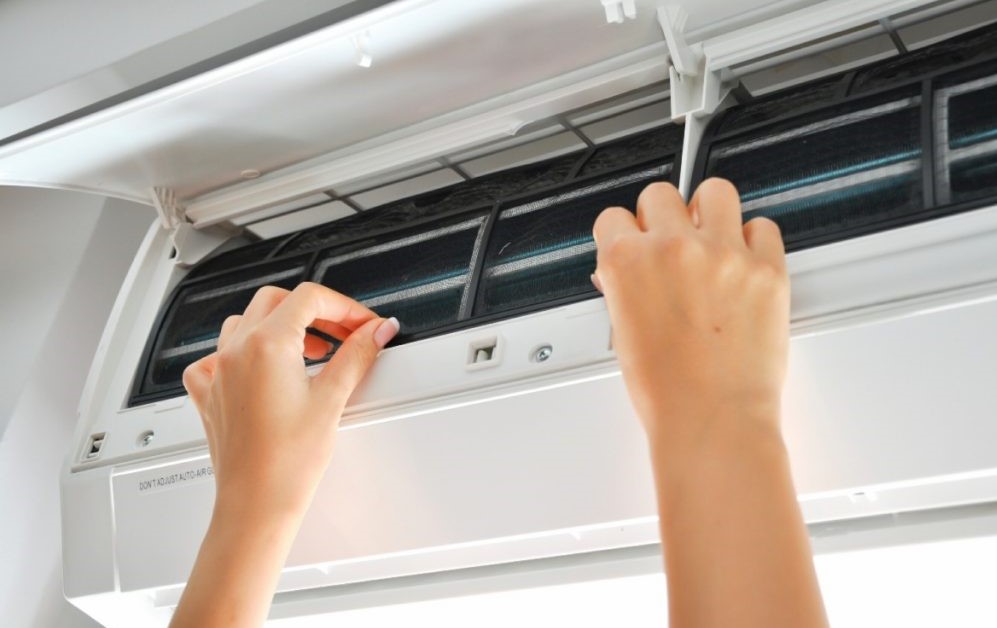 Nhân viên đang gỡ màng lọc máy lạnh để kiểm tra