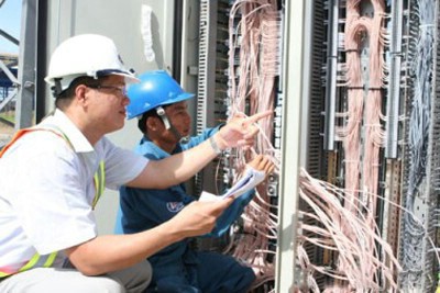 Giám sát viên và kỹ thuạt viên đang cùng xem xét hệ thống điện tại nhà máy