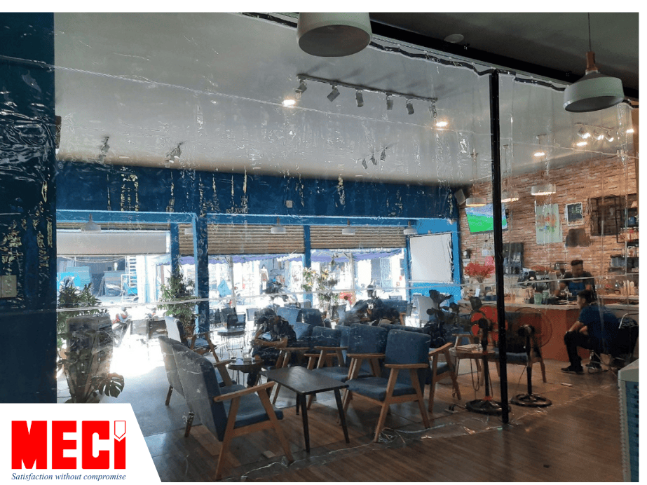 Quán cafe có rất nhiều khách hàng đang ngồi, được ngăn cách với không gian khác bằng tấm màn nhựa PVC trong suốt.