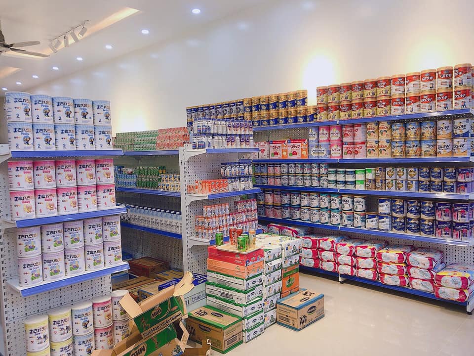 3 kệ sữa trong một cửa hàng đang được kiểm đếm và sắp xếp ngay ngắn song song nhau 