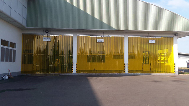 Hình ảnh nhà xưởng sử dụng rèm nhựa PVC màu vàng để ngăn bụi là biện pháp phòng chống bụi hiệu quả