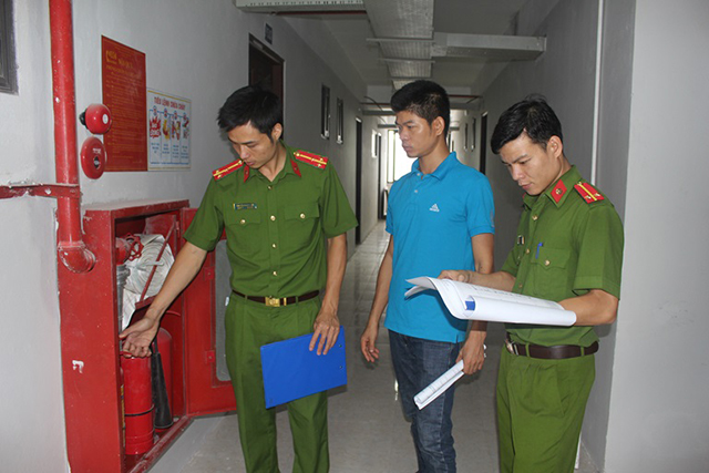 Cán bộ công an đang thực hiện kiểm tra an toàn cháy nổ trong doanh nghiệp