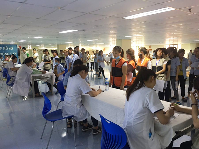 Những người công nhân đang xếp hàng để khám sức khỏe định kỳ