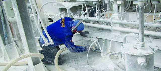 Một người đàn ông đã được trang bị đầy đủ công cụ phòng hộ để làm việc trong môi trường có nhiều bụi