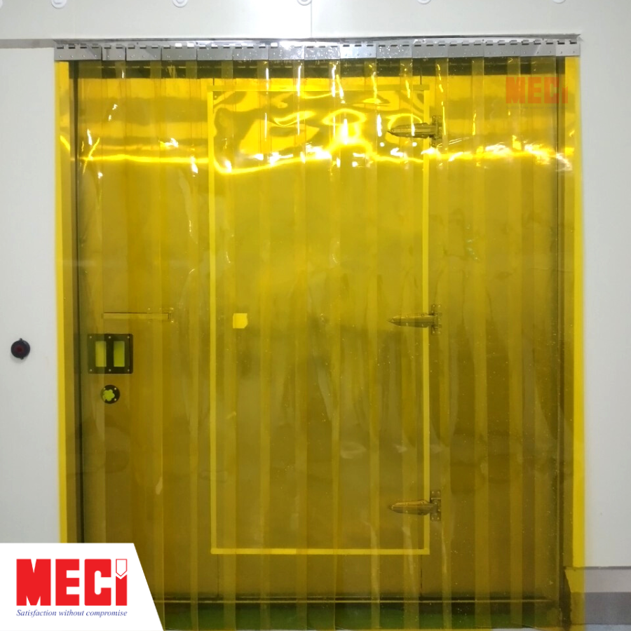 Rèm nhựa PVC thả sợi màu vàng được lắp tại cửa. Phía sau là cánh cửa đang đóng.