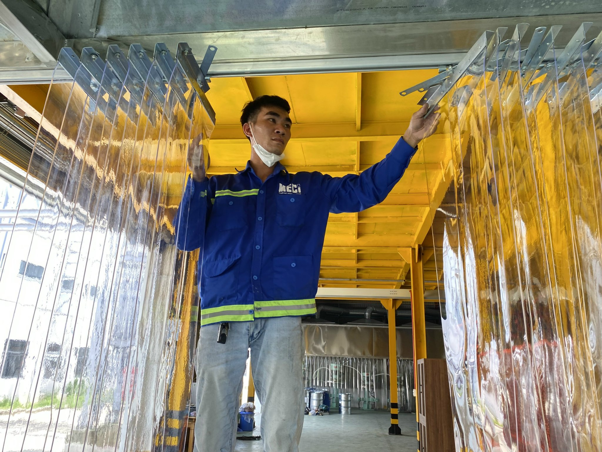 Tay người kỹ thuật MECI đang sử dụng rèm nhựa pvc xếp xoay