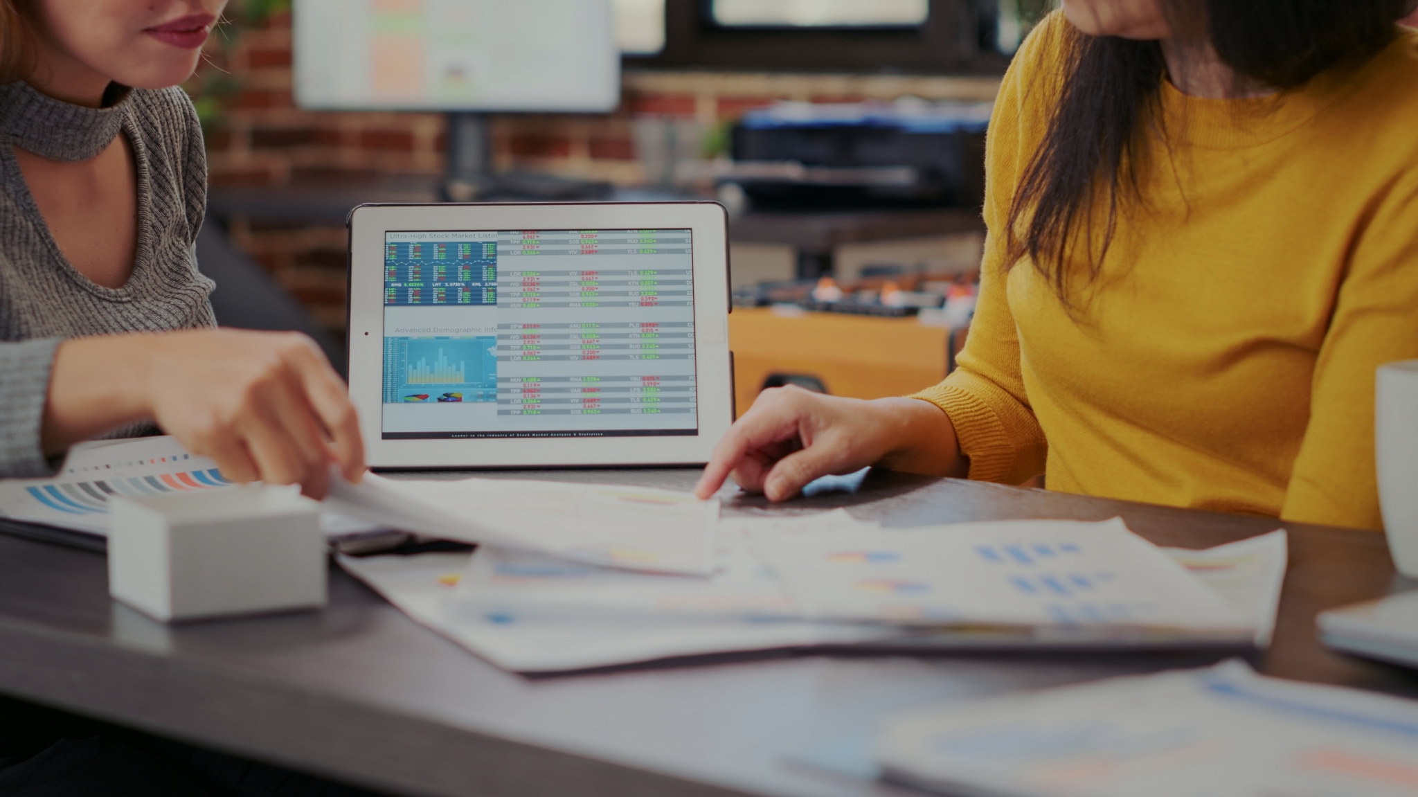 Hai người phụ nữ đang tìm hiểu các thông tin thị trường thông qua nghiên cứu số liệu 