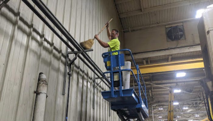 nhân viên dùng chổi để quét bụi