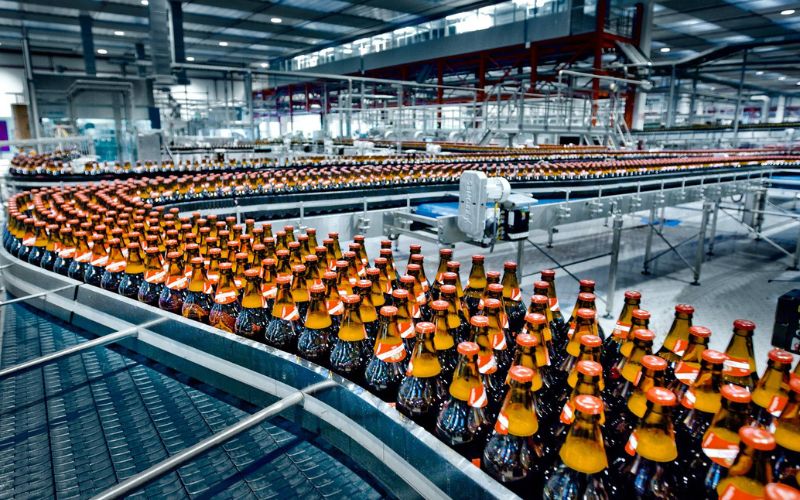 Nước ngọt đóng chai đang được vận chuyển trong dây chuyền sản xuất nước ngọt đóng chai