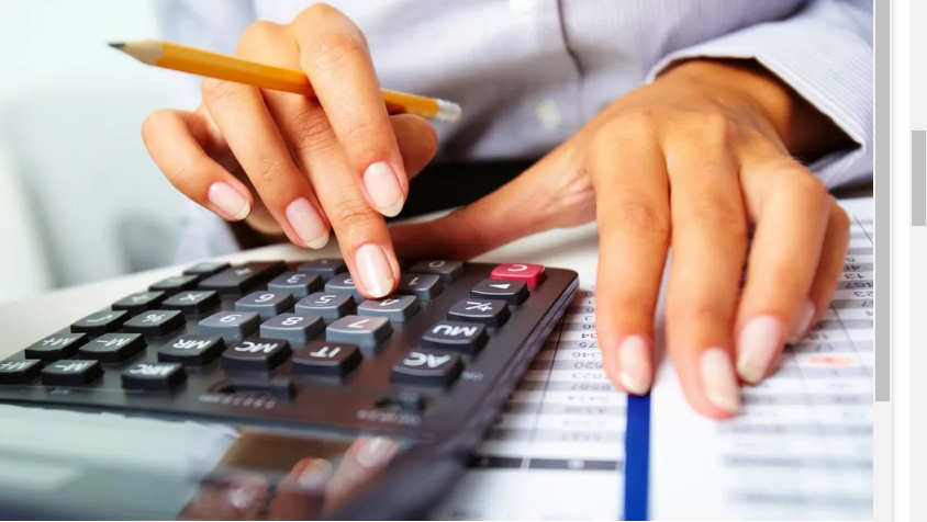 Một người đang dùng máy tính bỏ túi để kiểm tra lại các chi phí trong bảng báo cáo