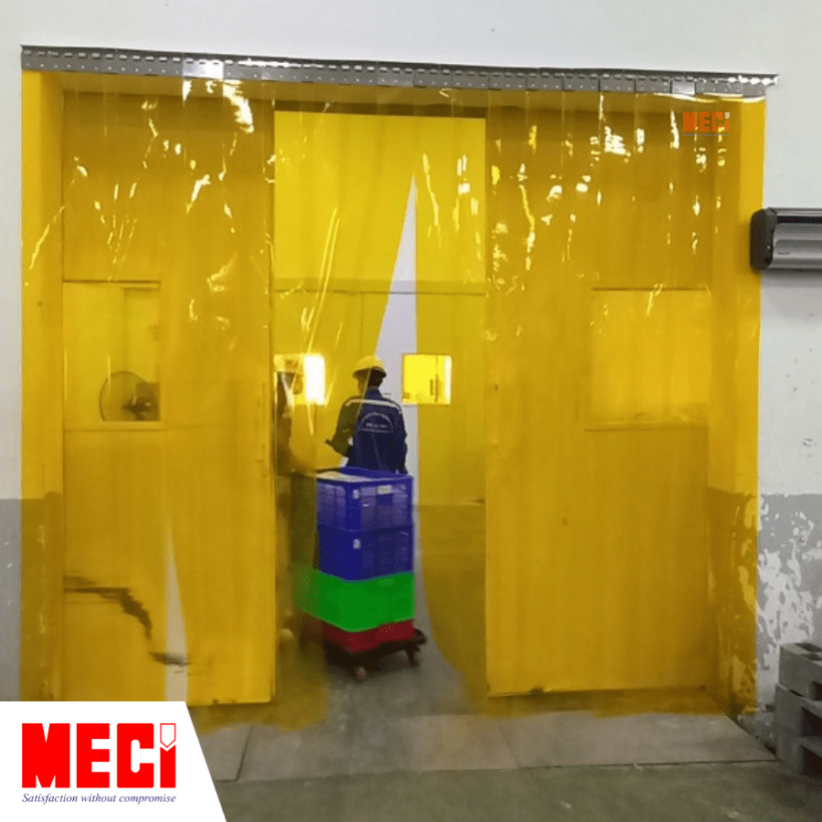 Một người di chuyển qua rèm nhựa màu vàng