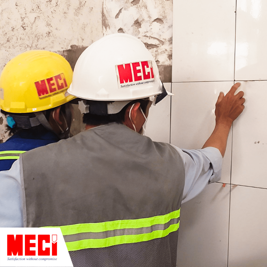 Hai người kỹ thuật đang ốp gạch lên tường