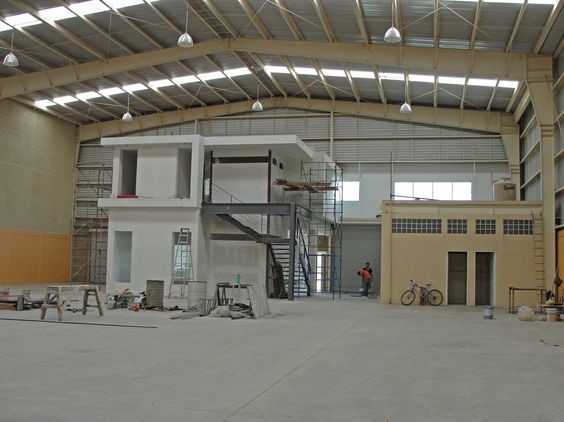 Nhà xưởng tích hợp văn phòng đang được xây dựng màu trắng, có trần nhà màu vàng.