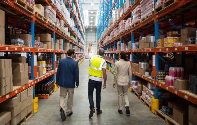 Hai người đàn ông và một người phụ nữ đang tiến hàng kiểm tra kho hàng