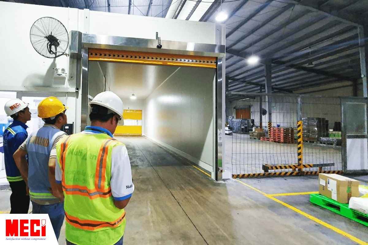 Nhân viên MECI và Nutifood đứng trước hai cửa cuốn nhanh PVC