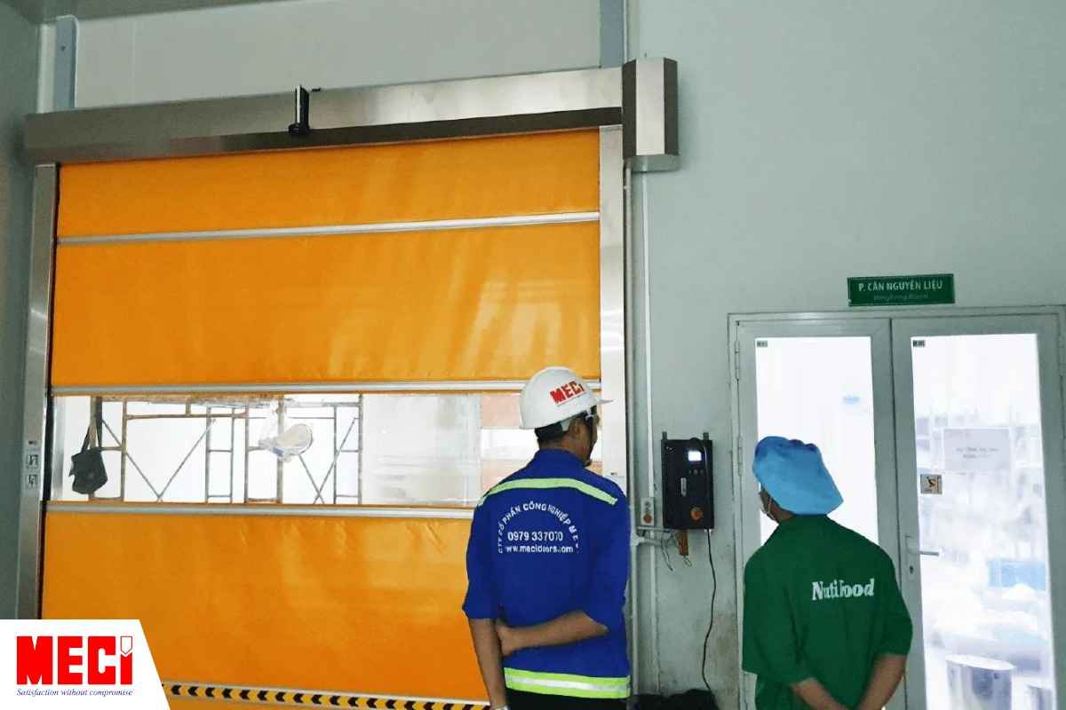 Nhân viên MECI và Nutifood đang đứng trước cửa cuốn nhanh PVC