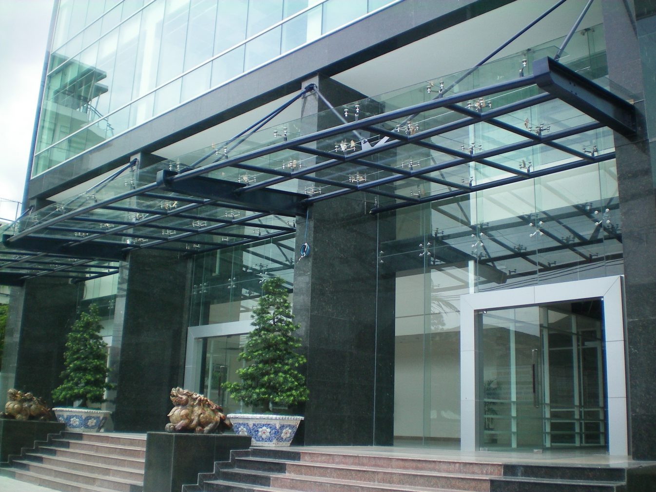 Mái che canopy kính cường lực trước của tòa nhà.