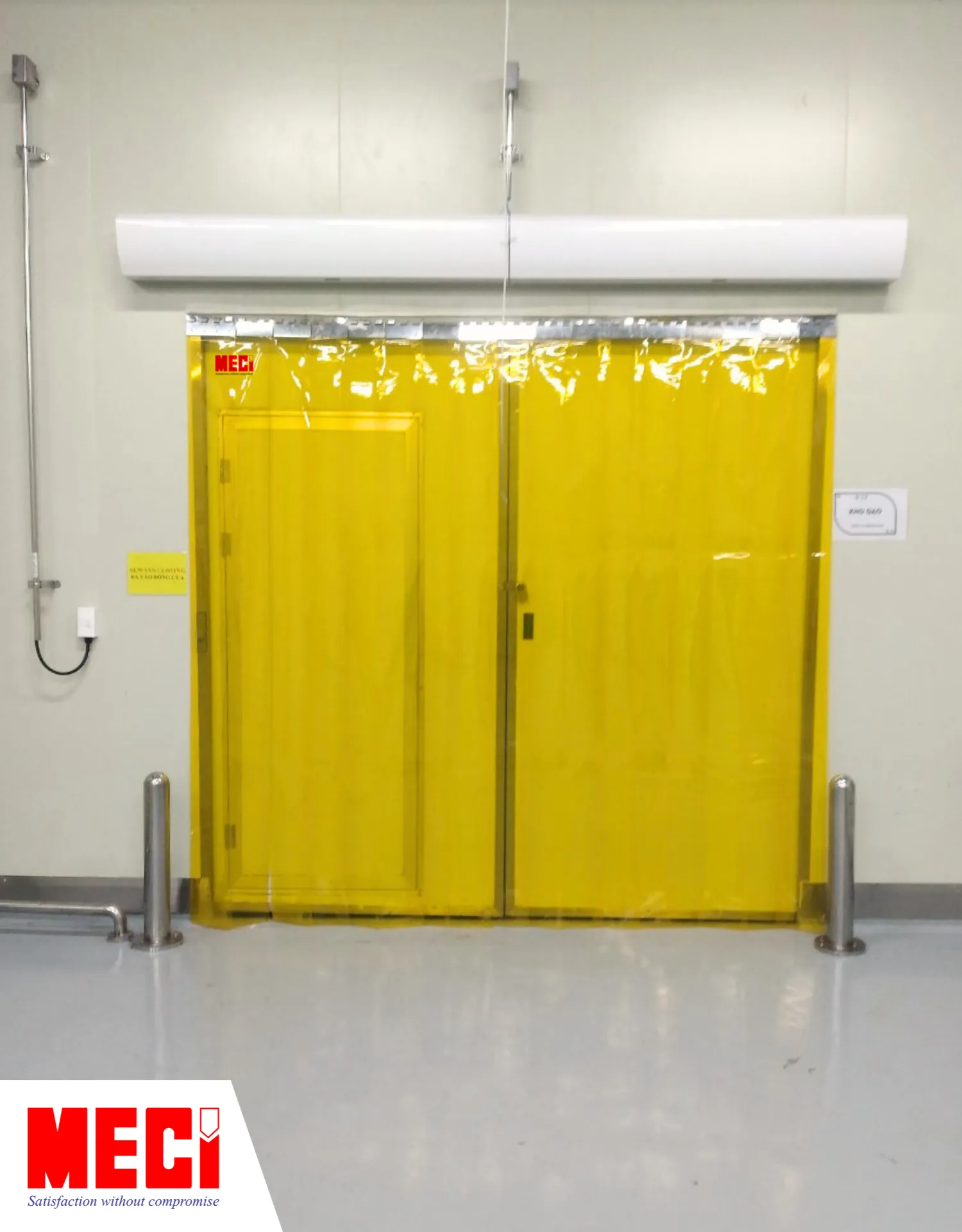 rèm nhựa PVC màu vàng được lắp kết hợp với cửa đóng mở 2 cánh trong phòng sạch, có hai chiếc quạt cắt gió phía trên