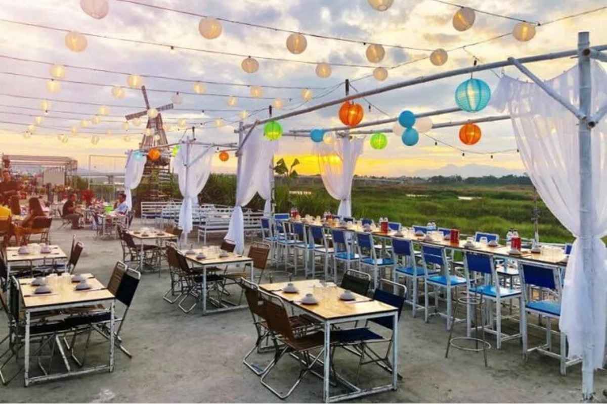 Một nhà hàng với không gian mở ngoài trời, có rất nhiều bàn ghế cùng decor đẹp mắt