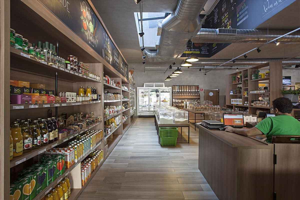 Hình ảnh mô tả không gian của một siêu thị bao gồm kệ trưng bày hàng hóa ở bên trái, giỏ hàng ở giữa và bên phải là quầy thanh toán.