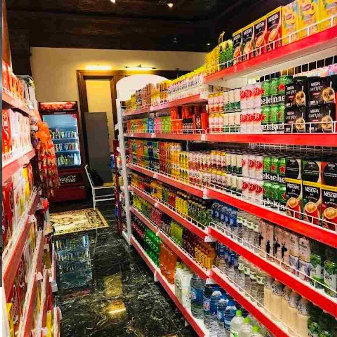 Hình ảnh mô tả các kệ hàng trong siêu thị, bên trên là hàng hóa được sắp xếp hợp lý với nhiều gam màu tươi như xanh, cam, vàng,… Lối đi ở giữa rộng rãi.