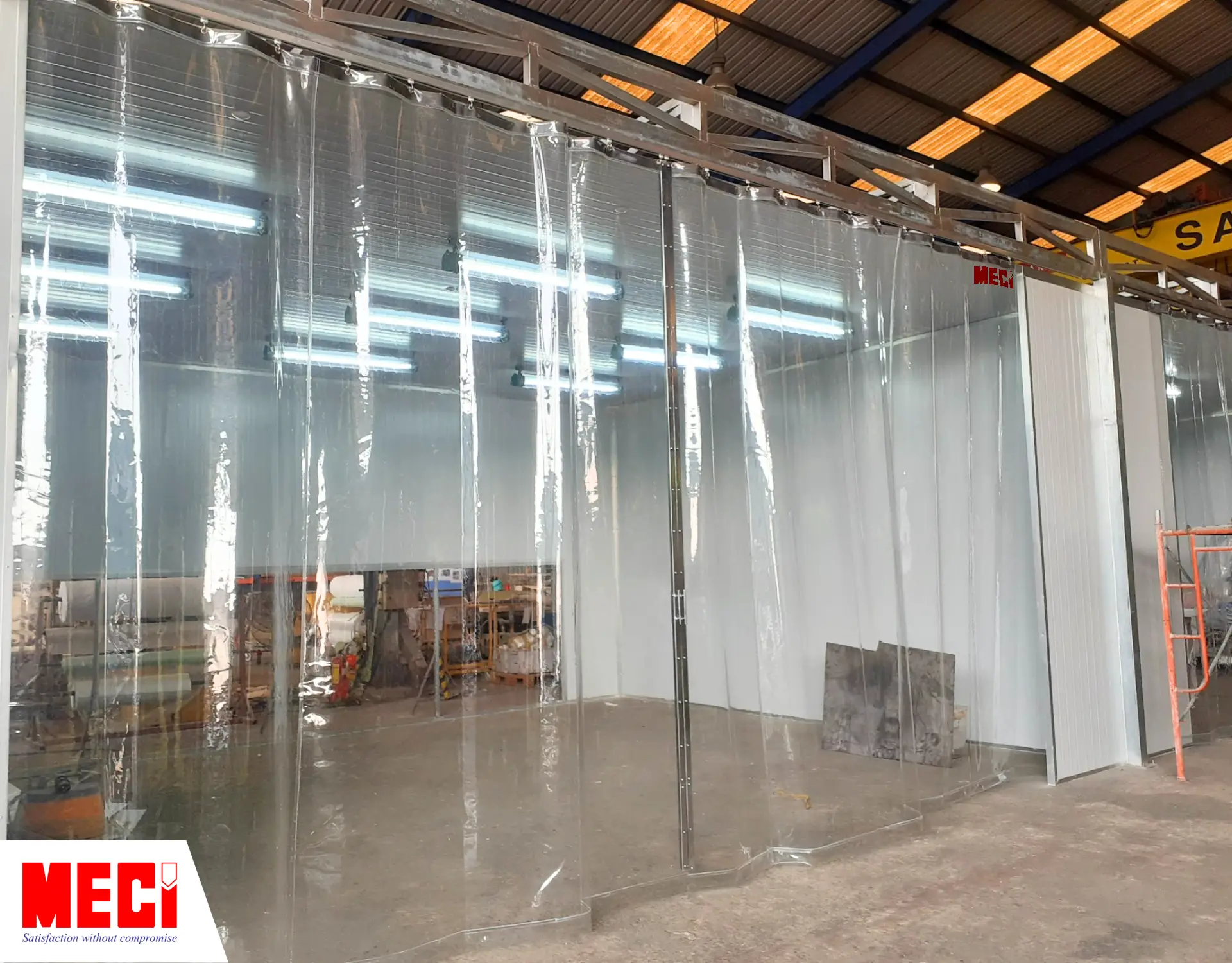 một buồng sơn phía trước có lắp rèm nhựa pvc hệ kéo dạt, rèm đang đóng lại