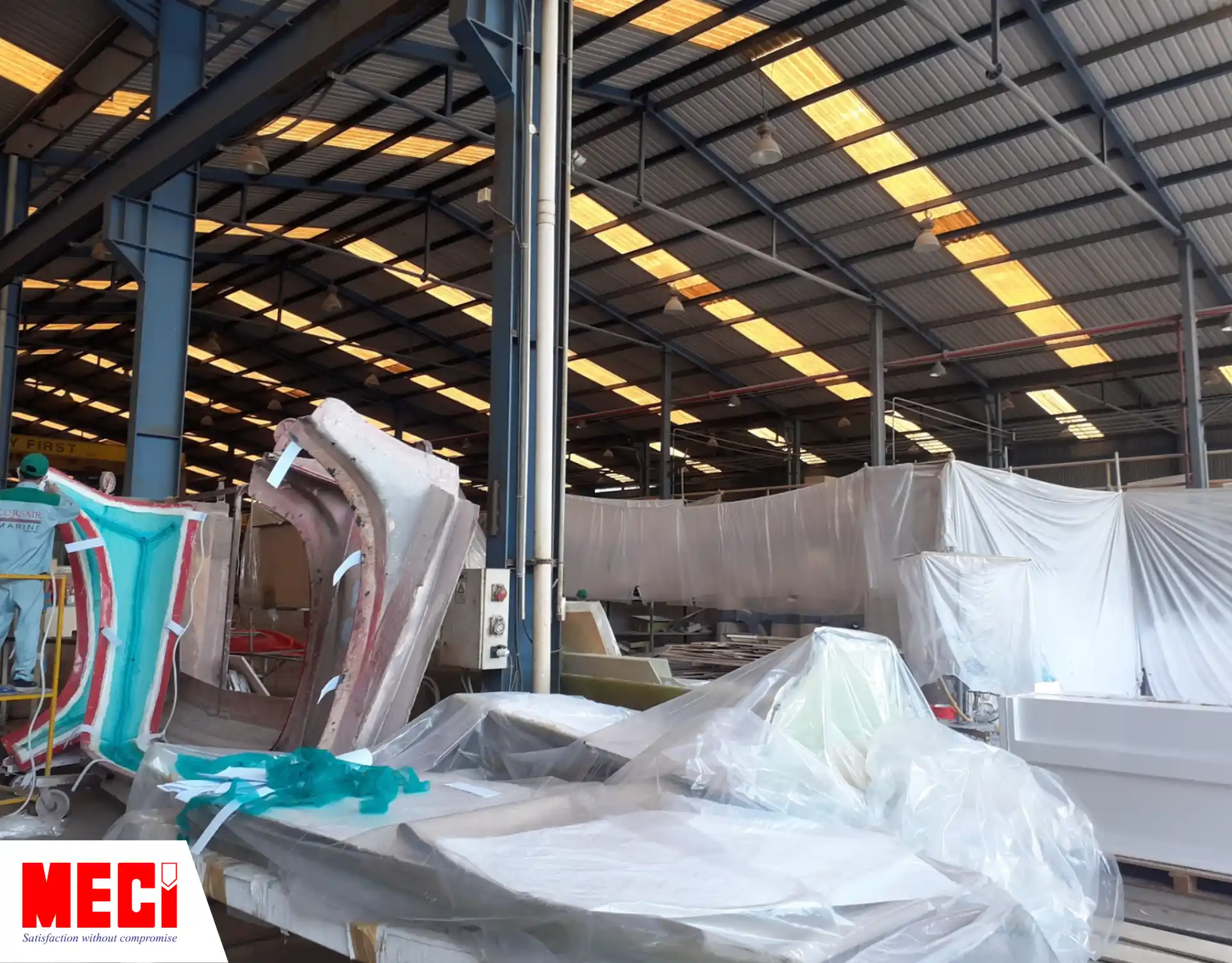 một góc xưởng đóng tàu có nhiều tấm nilon trắng bao quanh các khu vực