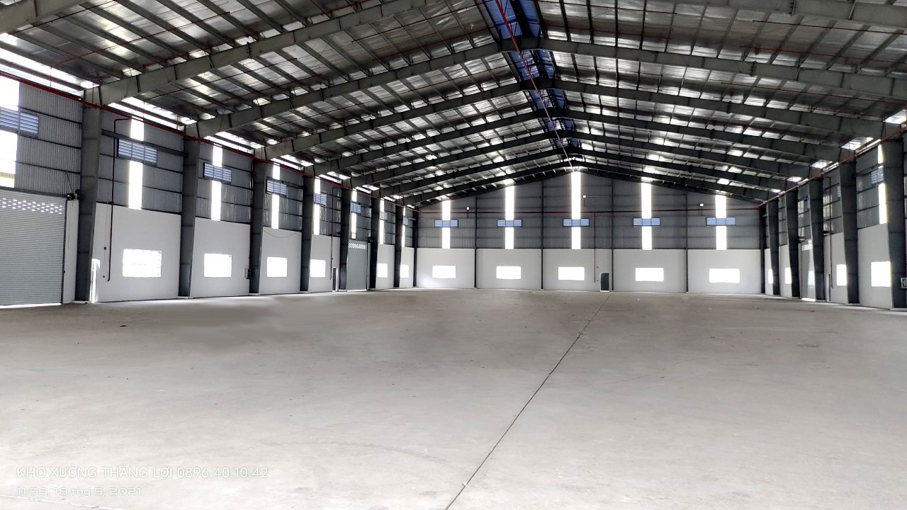 Nhà xưởng có nền màu trắng và mái tôn màu đen.