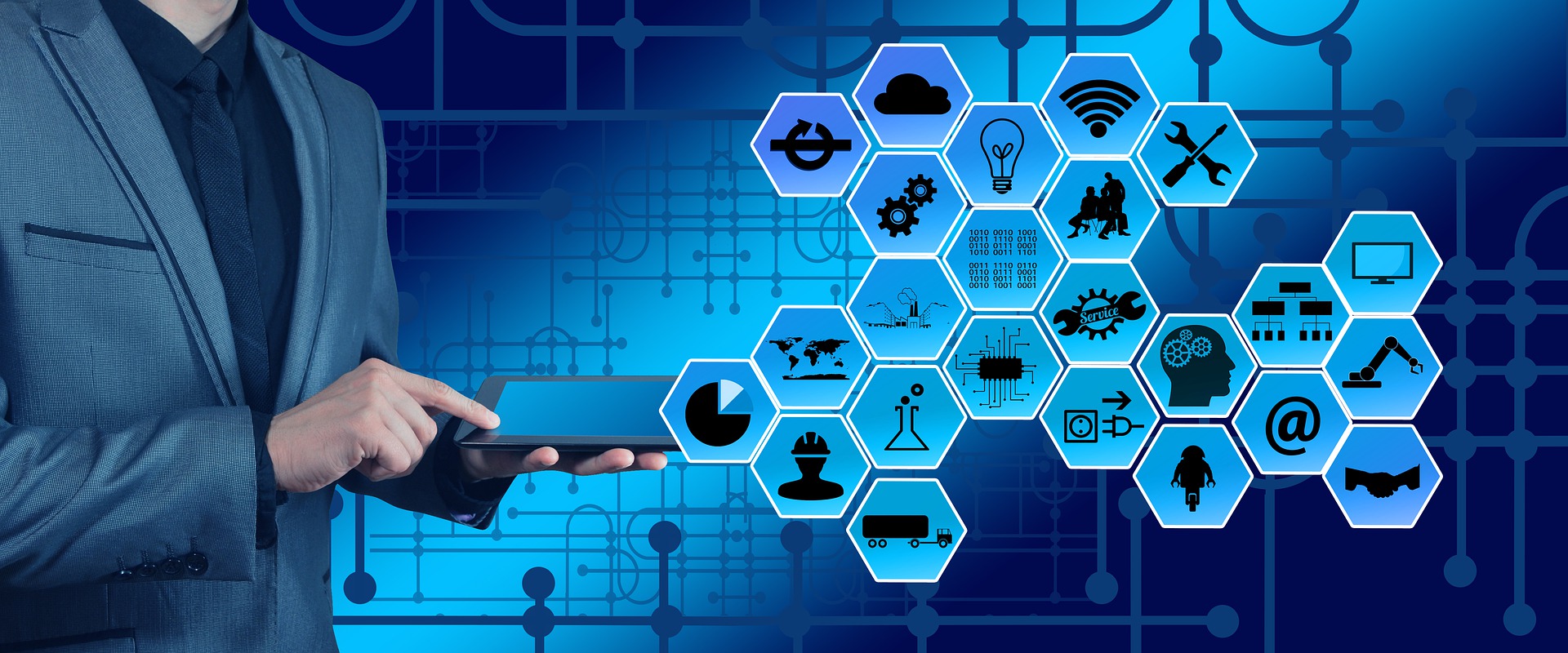 Một người có 1 tay cầm ipad, tay còn lại chỉ vào ipad hiển thị các ứng dụng.