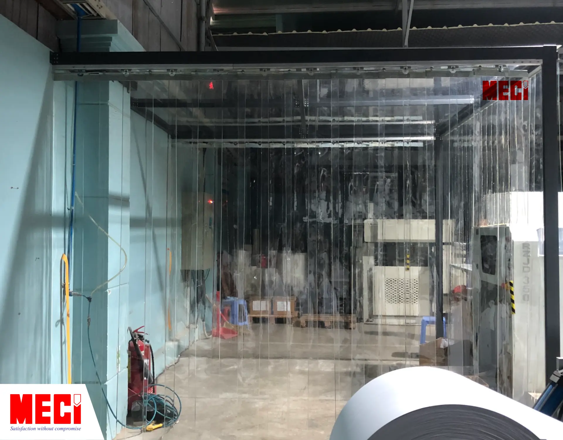 1 căn buồng nhỏ có hai mặt bên và mặt trước là rèm nhựa PVC thả sợi, mặt trên là vách ngăn nhựa, bên ngoài có nhiều máy móc