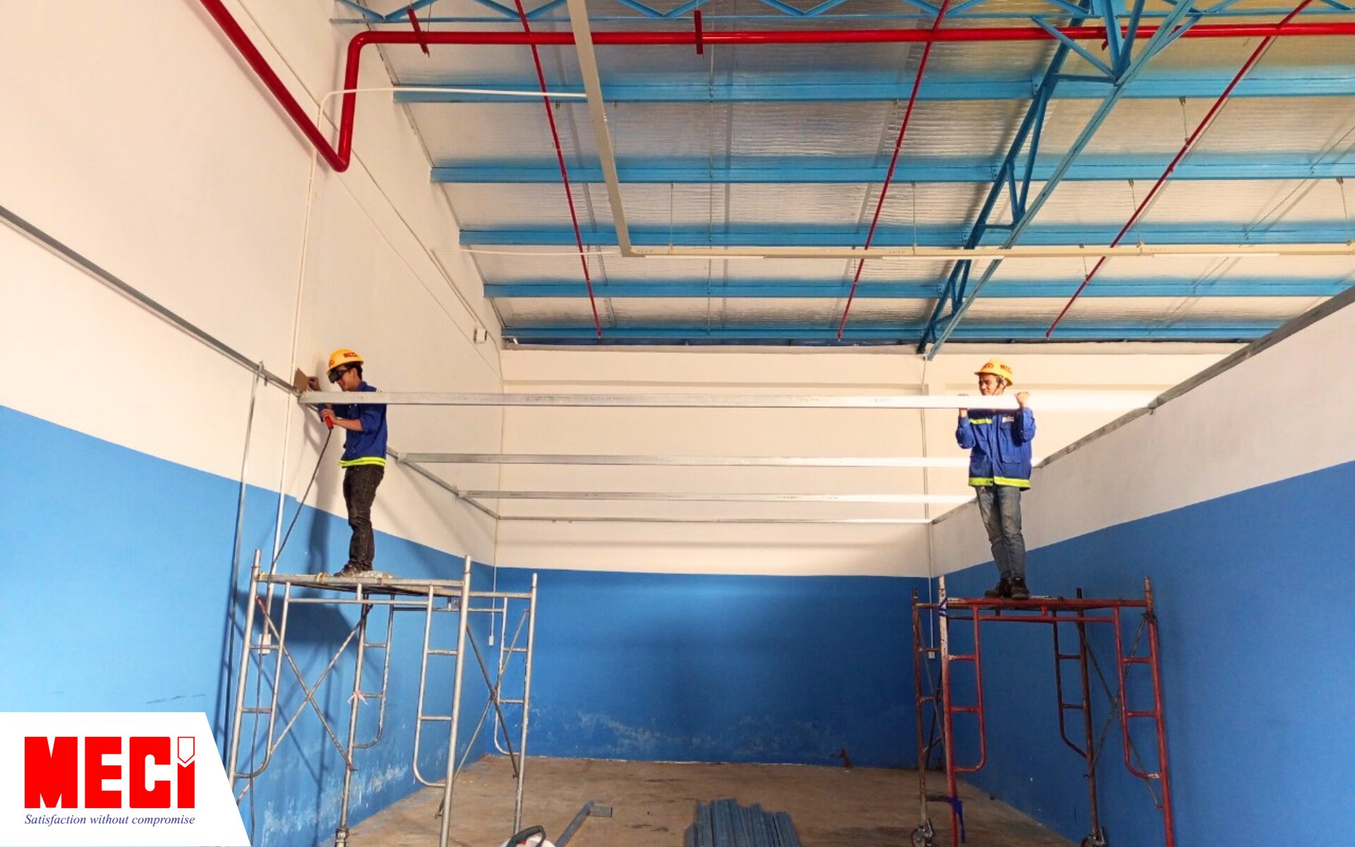 2 nhân viên MECI đang lắp đặt vách lưới tại nhà xưởng NutriNest