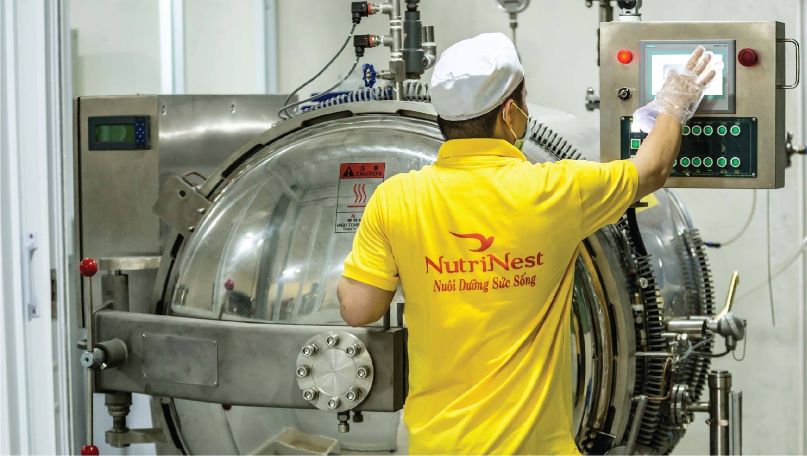 nhân viên NutriNest đứng trước máy đang sản xuất
