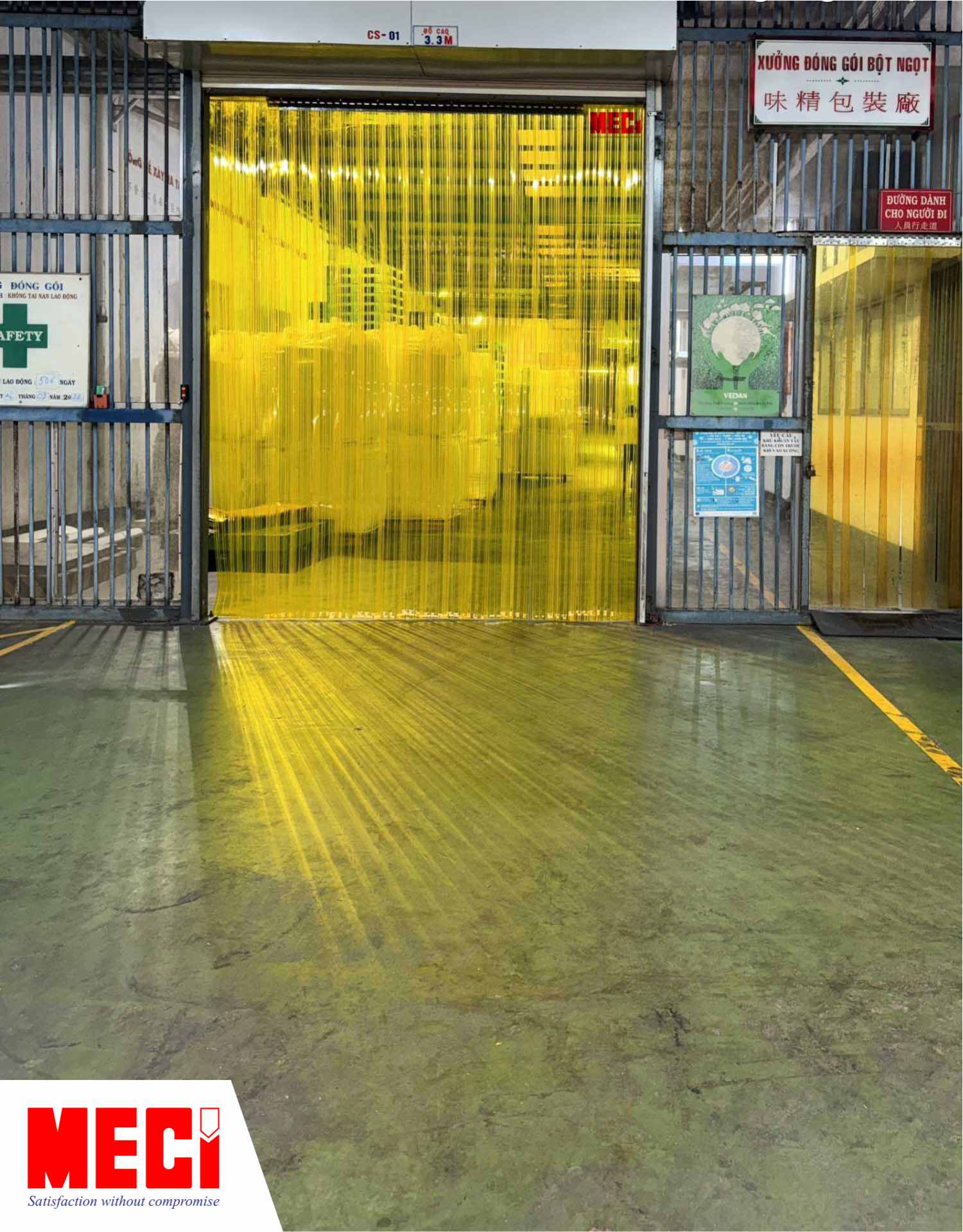 một bộ rèm nhựa PVC vàng lắp tại lối đi vào nhà kho có nhiều hàng hoá