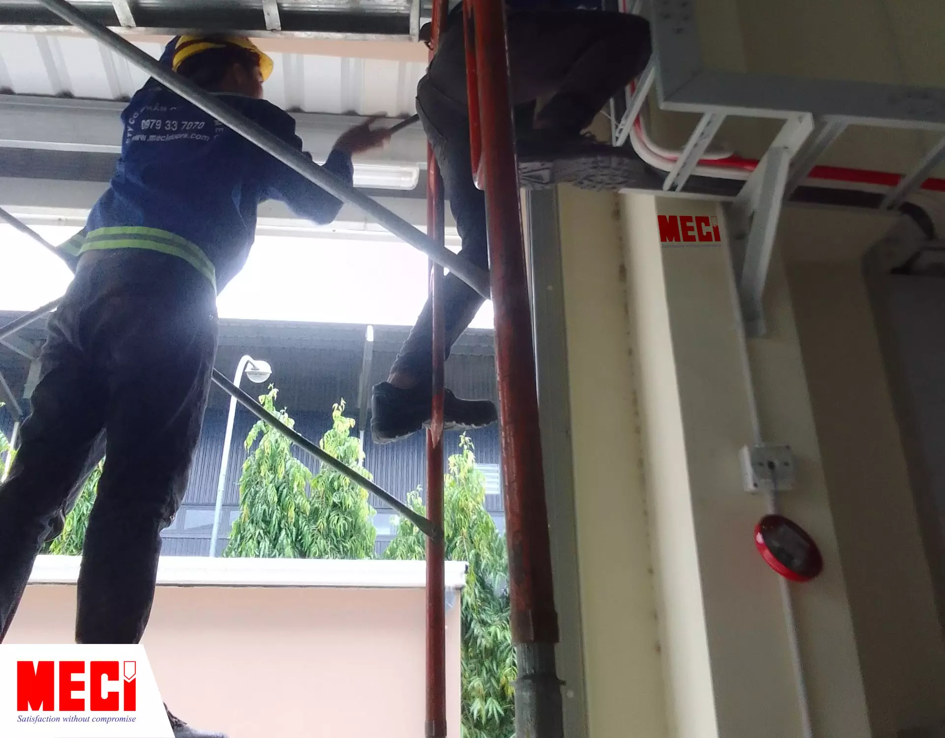 Hai nhân viên MECI đang lắp rèm nhựa tại công ty Ecopark Print
