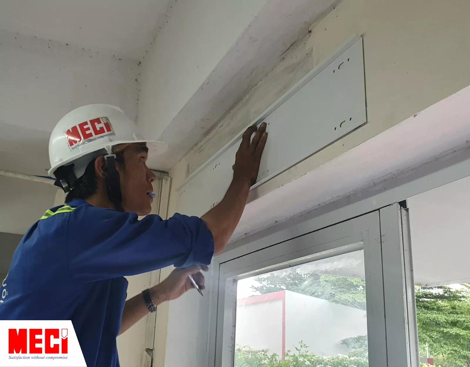 Kỹ thuật MECI đang đánh dấu vị trí khoan ốc vít để cố định đế quạt