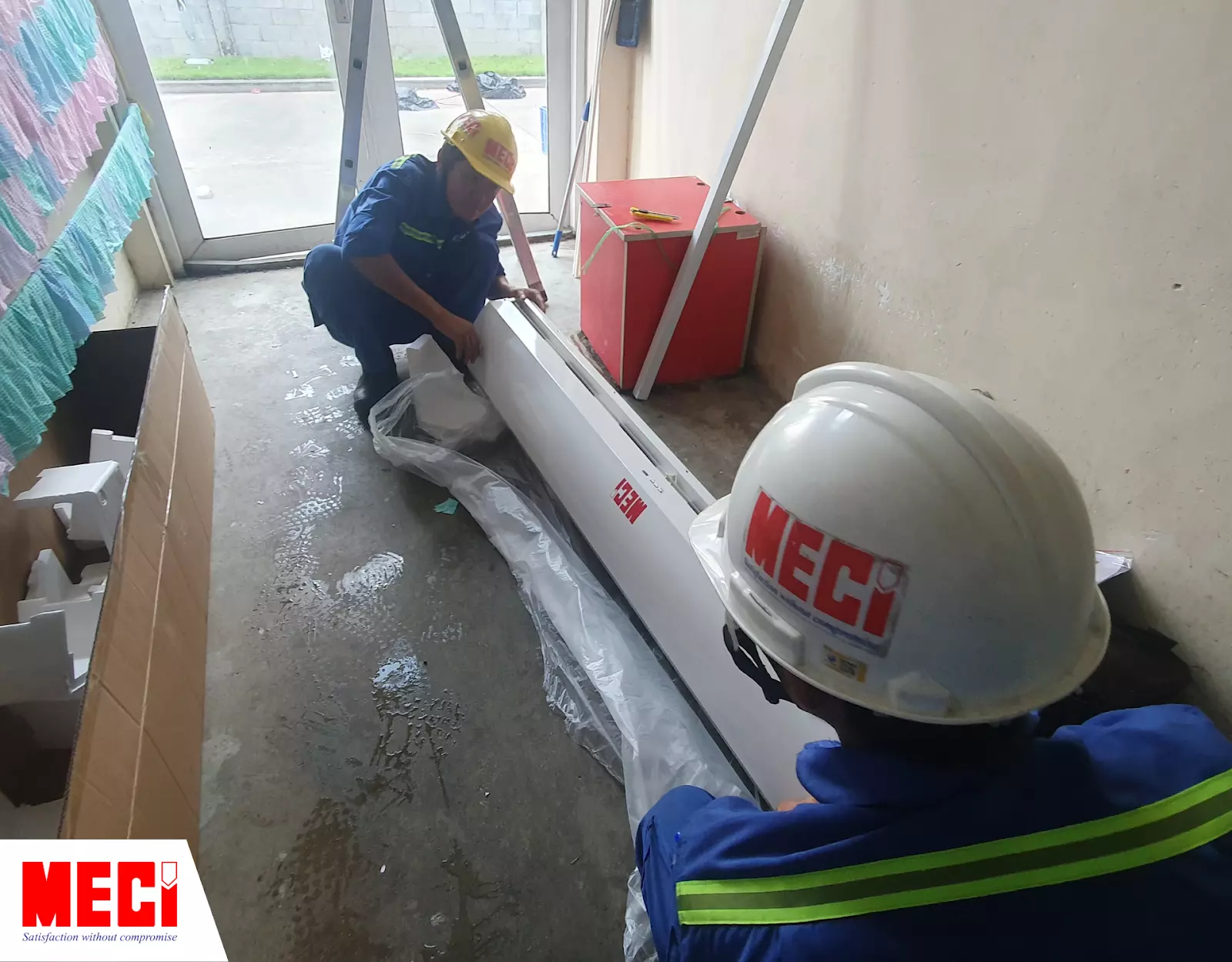 Hai kỹ thuật MECI đang tháo quạt ra khỏi vỏ bọc