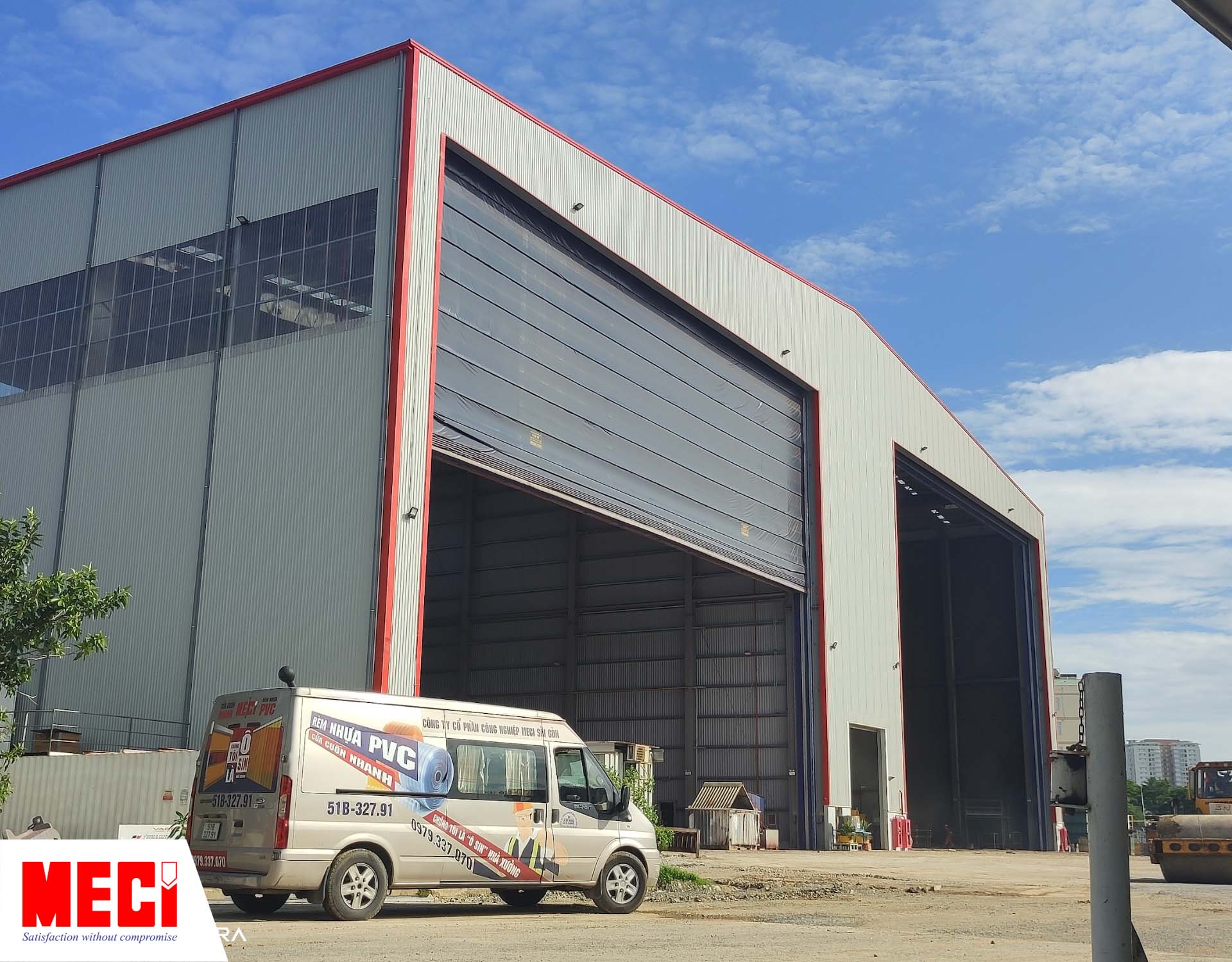 xe bán tải MECI đậu phía trước một nhà xưởng lớn