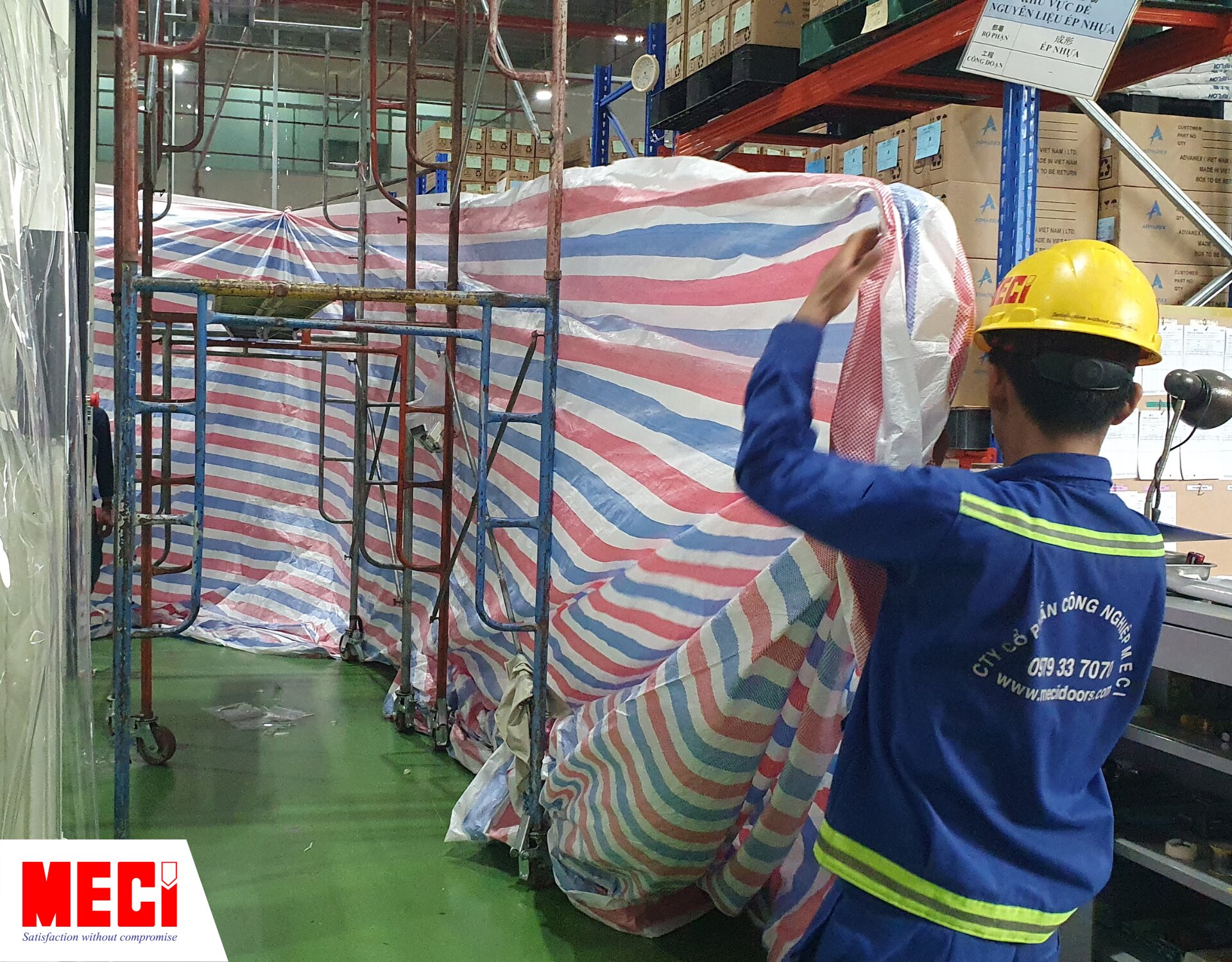 nhân viên MECI đang dùng tấm bạt bao quanh khu vực lắp đặt
