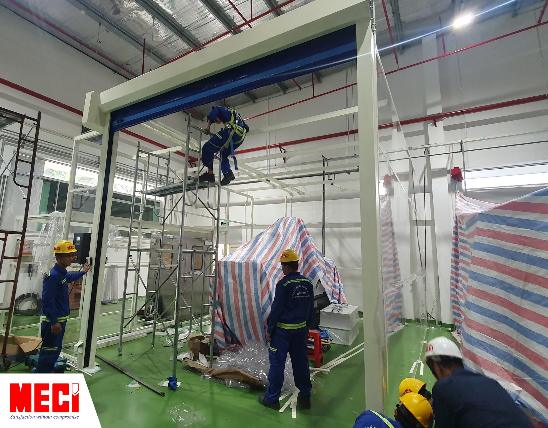 2 nhân viên MECI đang lắp đặt cửa cuốn nhanh PVC