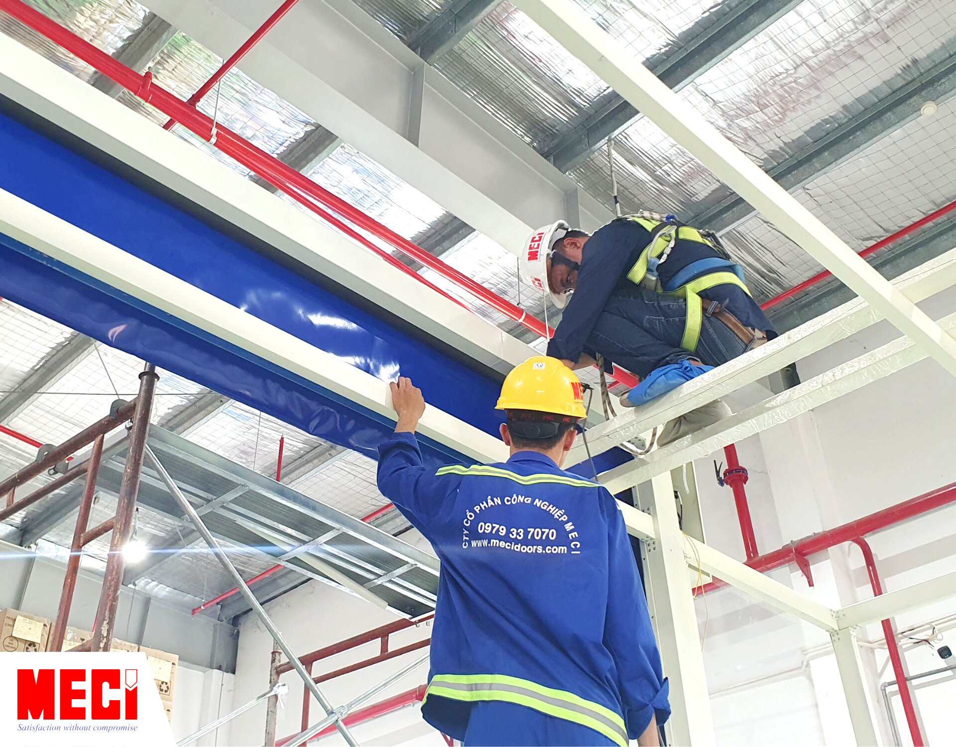 2 nhân viên MECI đang lắp đặt cửa cuốn nhanh PVC