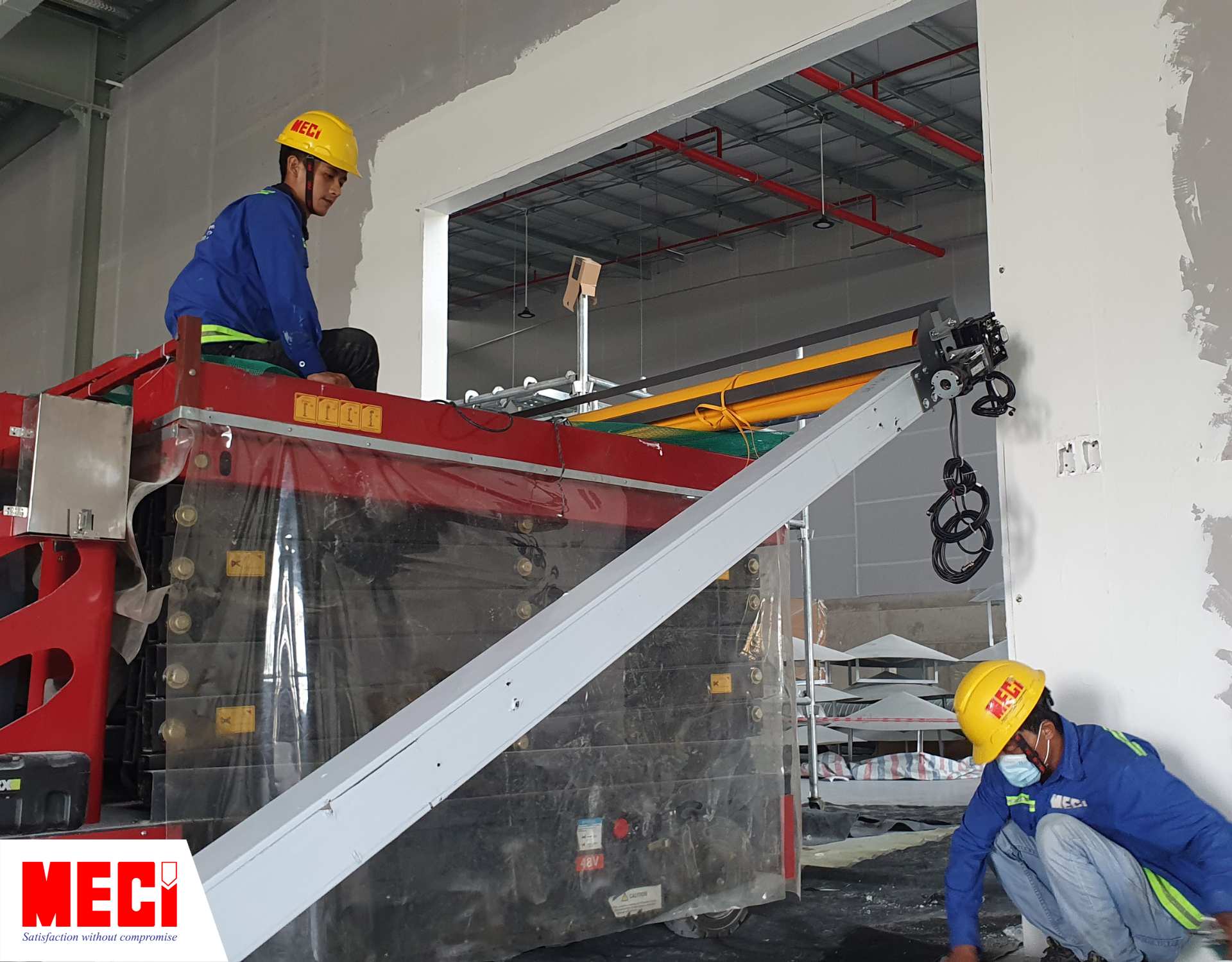 hai kỹ thuật viên nam đang nâng cái cửa cuốn nhanh PVC trên cái thang nâng