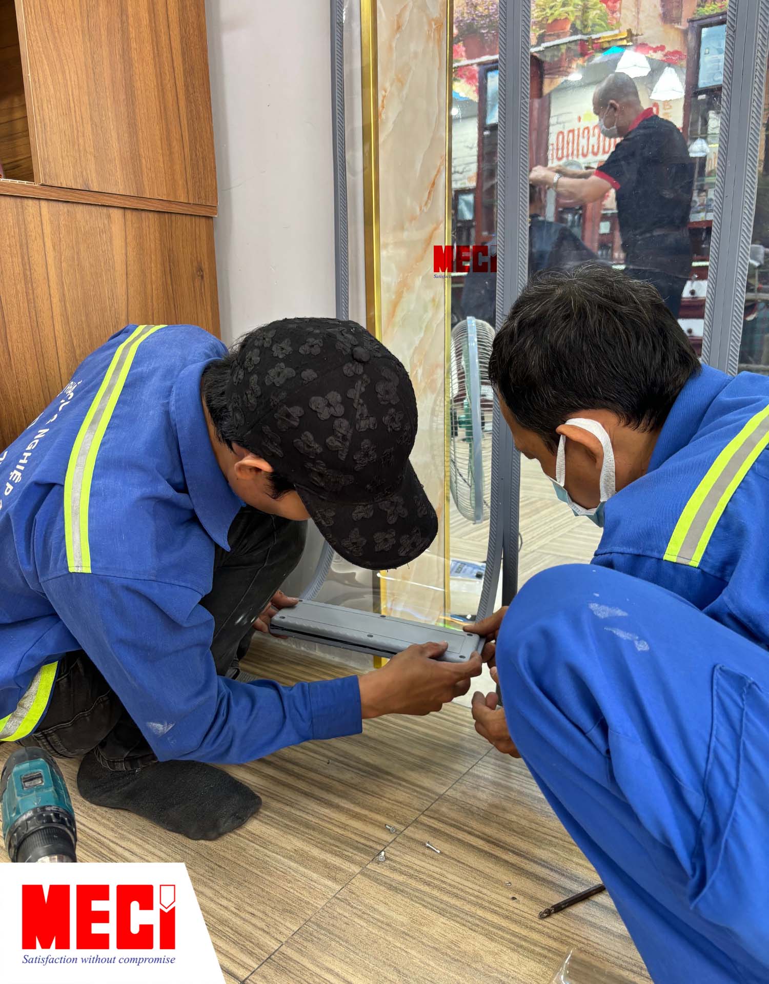 hai kỹ thuật viên nam đang nẹp tấm đối trọng nhựa vào chân các sợi rèm nam châm